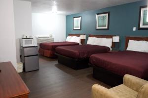 a hotel room with two beds and a tv at Juniper Motel Madras in Madras