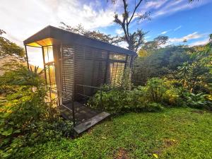a small building sitting on top of a field of grass at AsiaTica Lodge Volcano and Lake View in El Castillo de La Fortuna