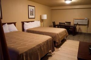 a hotel room with two beds and a table at Juniper Motel Madras in Madras