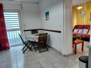 a room with a table and chairs and a bedroom at Nid du Lagon in Sainte-Anne