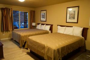 a hotel room with two beds and a window at Juniper Motel Madras in Madras