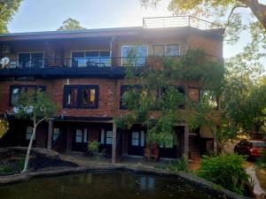 a brick house with a pond in front of it at Vintara Wild Hambanthota in Hambantota