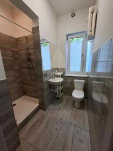 a bathroom with a toilet and a shower and a sink at Pokoje na lato Gdynia in Gdynia