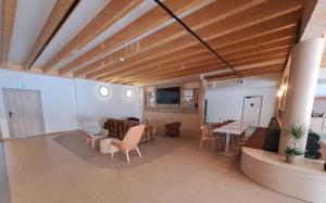 a living room with wooden ceilings and a table and chairs at KYRIAD PRESTIGE - PIERRELATTE in Pierrelatte