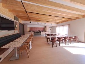 a large room with tables and chairs and a kitchen at KYRIAD PRESTIGE - PIERRELATTE in Pierrelatte