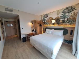 a bedroom with a white bed and a mural on the wall at KYRIAD PRESTIGE - PIERRELATTE in Pierrelatte +31 photos