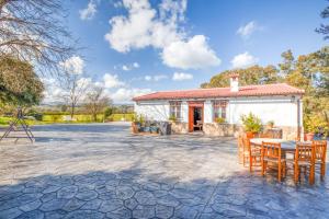 a patio with a table and chairs in front of a building at Casa Rural Vega el Dorado in San Pablo