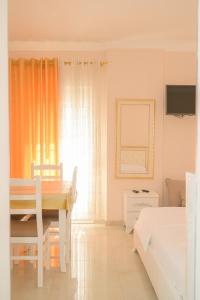 a white room with a dining table and a bed at Vila Vitoria in Shëngjin