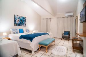 a bedroom with a large bed and a chair at Hotel Portal do Descobrimento in Porto Seguro +63 photos