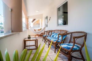 a room with chairs and a hammock on a porch at Hotel Portal do Descobrimento in Porto Seguro