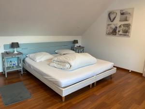 a bed with two pillows on it in a room at La cour des hôtes in Fenain