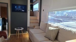 a living room with a couch and a window at Duerme en un barco in Moaña