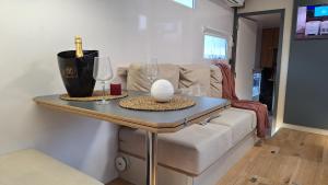 a living room with a table with wine glasses and a couch at Duerme en un barco in Moaña
