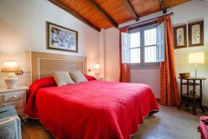 a bedroom with a red bed and a window at Casa Rural Vega el Dorado in San Pablo +22 photos