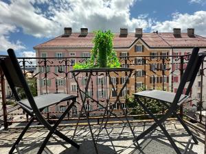 a table and chairs with a plant on a balcony at Abeilles in La Chaux-de-Fonds