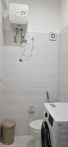 a white bathroom with a toilet and a machine at Kaza Branka in Sal Rei +7 photos