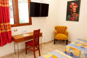 a bedroom with a desk and a chair and a bed at Hotel Dainzu in Oaxaca City