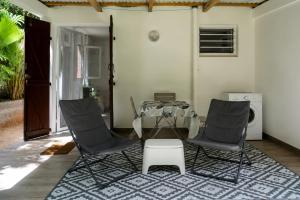 a room with a table and two chairs and a table at Kay Canou - Vue jardin tropical - Calme & nature in Le Robert +4 photos