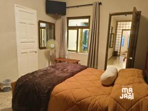 a bedroom with a bed with an orange blanket at Hotel Casa Majaal in Ixtapan de la Sal