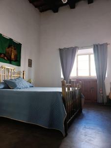 a bedroom with a bed and a window at La Casa de Lalo in Cafayate