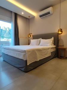 a bedroom with a large bed with two lights on it at Meteora Gold and Glass in Kalabaka