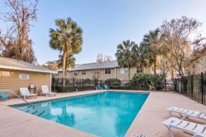 a swimming pool with chairs and a fence at The Prairie at Brighton - UF , Pool , Workspace in Gainesville