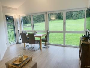 a dining room with a table and chairs and windows at Ferienwohnung Hoherting in Prien am Chiemsee