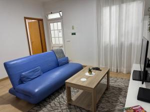 a blue couch in a living room with a table at Alforra Residence 1-T2-centro-praias-Levadas in Câmara de Lobos