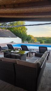 a patio with chairs and tables and a pool at Kuća za odmor Terra Marta in Đakovo