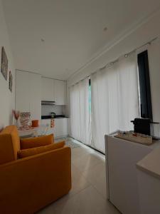 a living room with two orange chairs and a kitchen at Al58 Casa Vacanze in Villasmundo