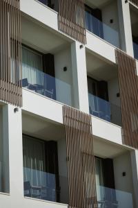 an apartment building with balconies and chairs at Magnus Hotel & SPA in Vlorë