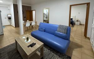 a blue couch in a living room with a table at Alforra Residence 1-T2-centro-praias-Levadas in Câmara de Lobos