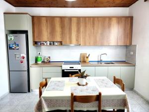 a kitchen with a table and a refrigerator at Mia Guest House - Entire home with balcony & garden in Divjakë