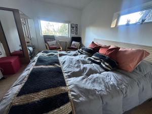 a bedroom with a large bed with pillows on it at Casita Bosque-Rucalemu in Valdivia