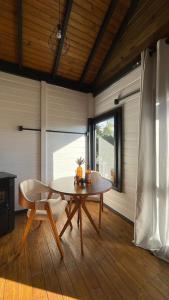 a dining room with a table and a chair at NOVIDADE - Cabana Refúgio Gaia in Annitapolis +6 photos