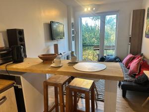 a kitchen with a wooden table with stools and a dining room at Casita Bosque-Rucalemu in Valdivia