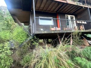 a house with two chairs on a balcony at Casita Bosque-Rucalemu in Valdivia
