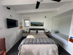 a bedroom with two beds and a flat screen tv at Beach view studio 337 in Omapere