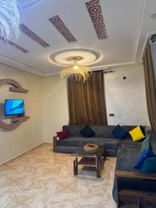 a living room with a couch and a tv at maison de bonheur 2 in Tafraout