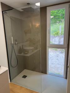 a bathroom with a shower with a sink and a window at Casa Broullón in Moaña +11 photos