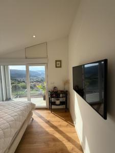 a bedroom with a large flat screen tv on the wall at Casa Broullón in Moaña