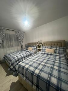 a bedroom with two beds and a chandelier at Modern House in Dublin15, Great Location Near Dublin Airport in Tyrrelstown