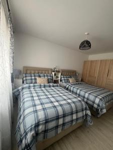 a bedroom with two beds with plaid sheets at Modern House in Dublin15, Great Location Near Dublin Airport in Tyrrelstown