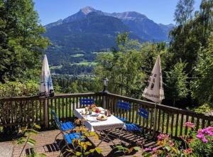 a table and chairs on a balcony with mountains at Ferienwohnung Bischofshäusl in Berchtesgaden
