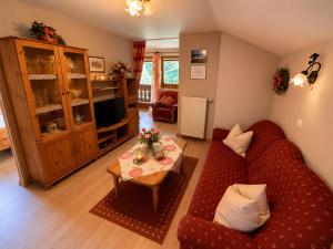 a living room with a red couch and a table at Ferienwohnung Bischofshäusl in Berchtesgaden
