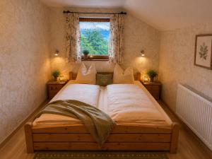 a large bed in a bedroom with a window at Ferienwohnung Bischofshäusl in Berchtesgaden
