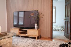 a living room with a flat screen tv on a stand at Belmont Station in Belmont