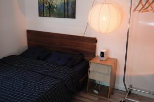 a bedroom with a bed and a table with a lamp at Belmont Station in Belmont