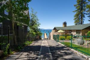 an empty street in front of a house with a fence at Foothill Folly home in Zephyr Cove