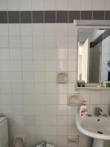 a white tiled bathroom with a sink and a mirror at dana beach resort in Half Moon Bay +19 photos